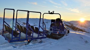 Alpebuss for frakt av gjester om vinteren i kveldssol