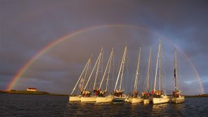 7 seilbåter under regnbuen på Helgelandskysten
