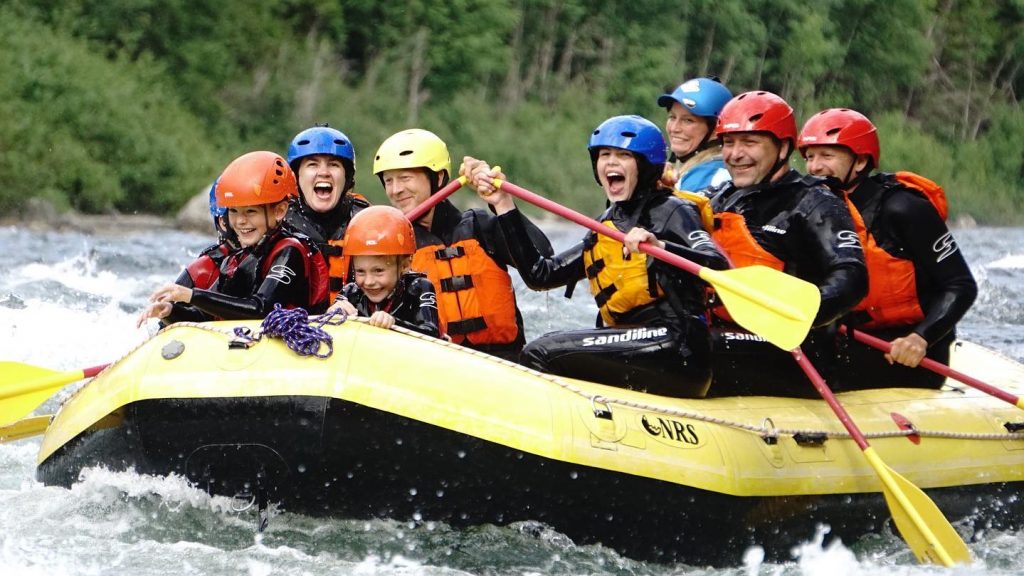 Rafting i Auster-Vefsnav i gul båt full av glade folk.