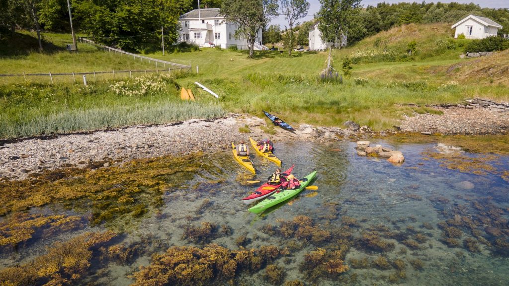 Familie gjør seg klar til en guidet kajakktur utenfor Røssøygården i Lurøy