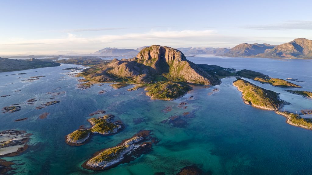 Sagnfjellet Torghatten sett fra lufta med byen Brønnøysund et stykke i bakgrunnen