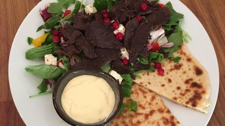 Suovas servert på salat med samisk brød og dressing ved siden av