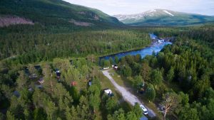 Krokstrand Fjellpark med fjell, elv og camping sett ovenfra med drone
