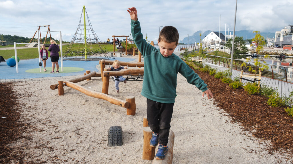 Barn og familier på lekeplassen på Lille Brønnøya Folkepark i Brønnøysund en sommerdag