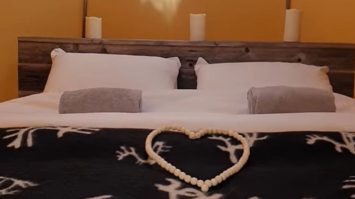 Oppreid seng i luksusgamme med samisk dekor