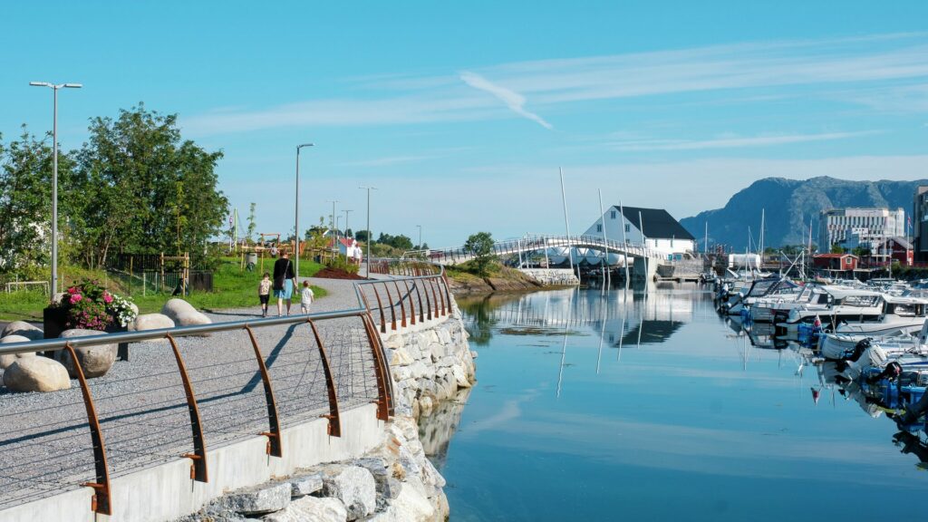 Family with small children walking along the water in Brønnøysund on a beautiful summer day