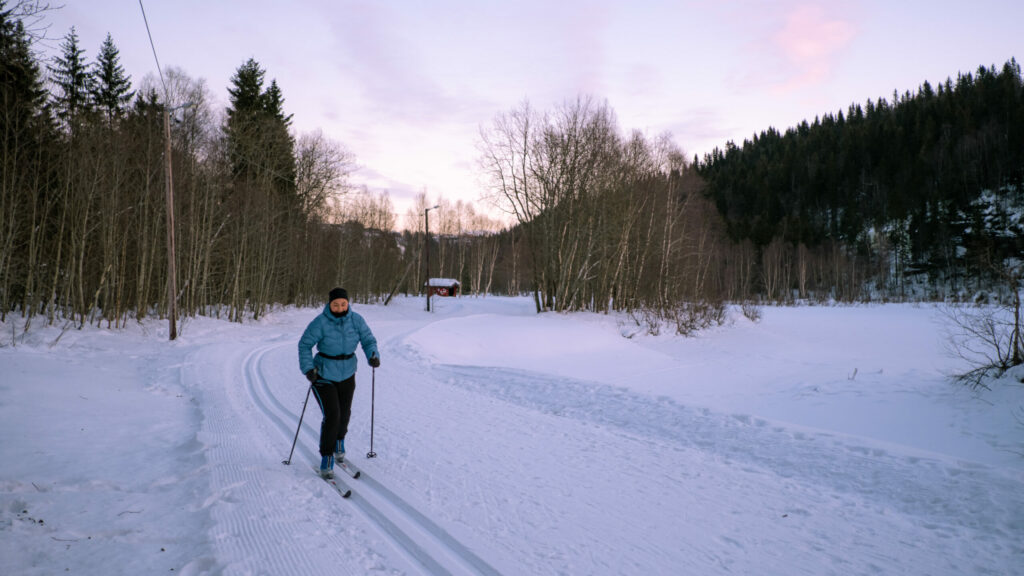 Jente som går på ski i et skispor.