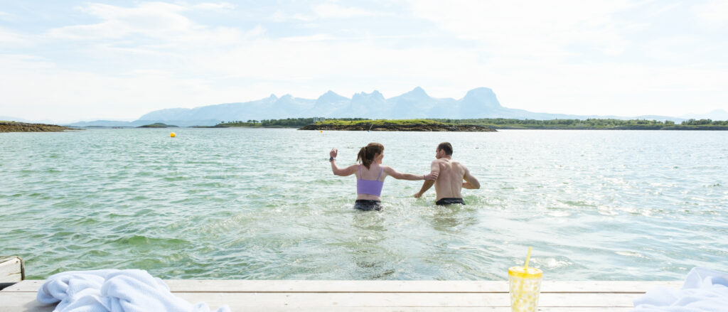 To personer bader ved stranda Rakelfjæro på Herøy