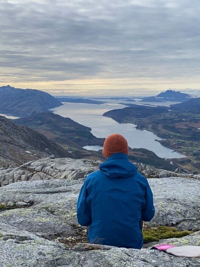 Mann sitter å speider utover utsikten på Klampen langs kysten